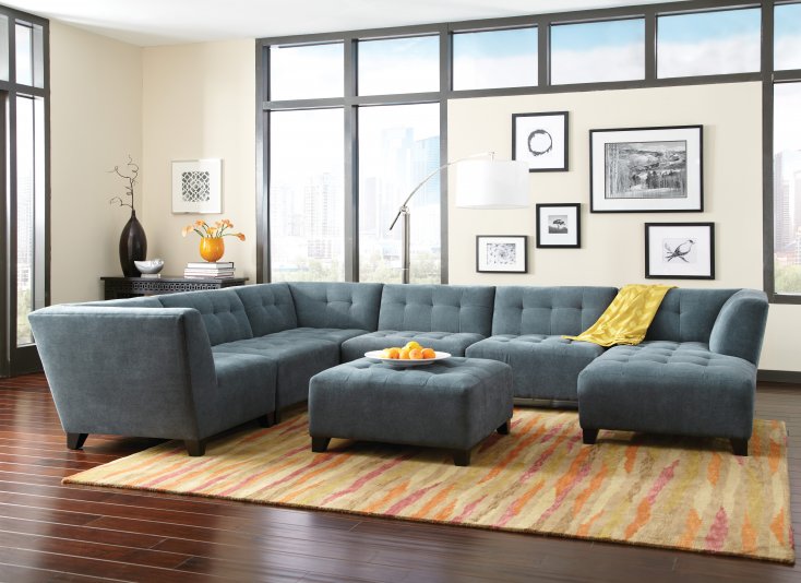 Consider livening up the color of your living room by adding colors from nature. Here, touches of orange and yellow give life to the neutral backdrop. (Featured set is from the Belaire Living Room Collection of Jonathan Louis)